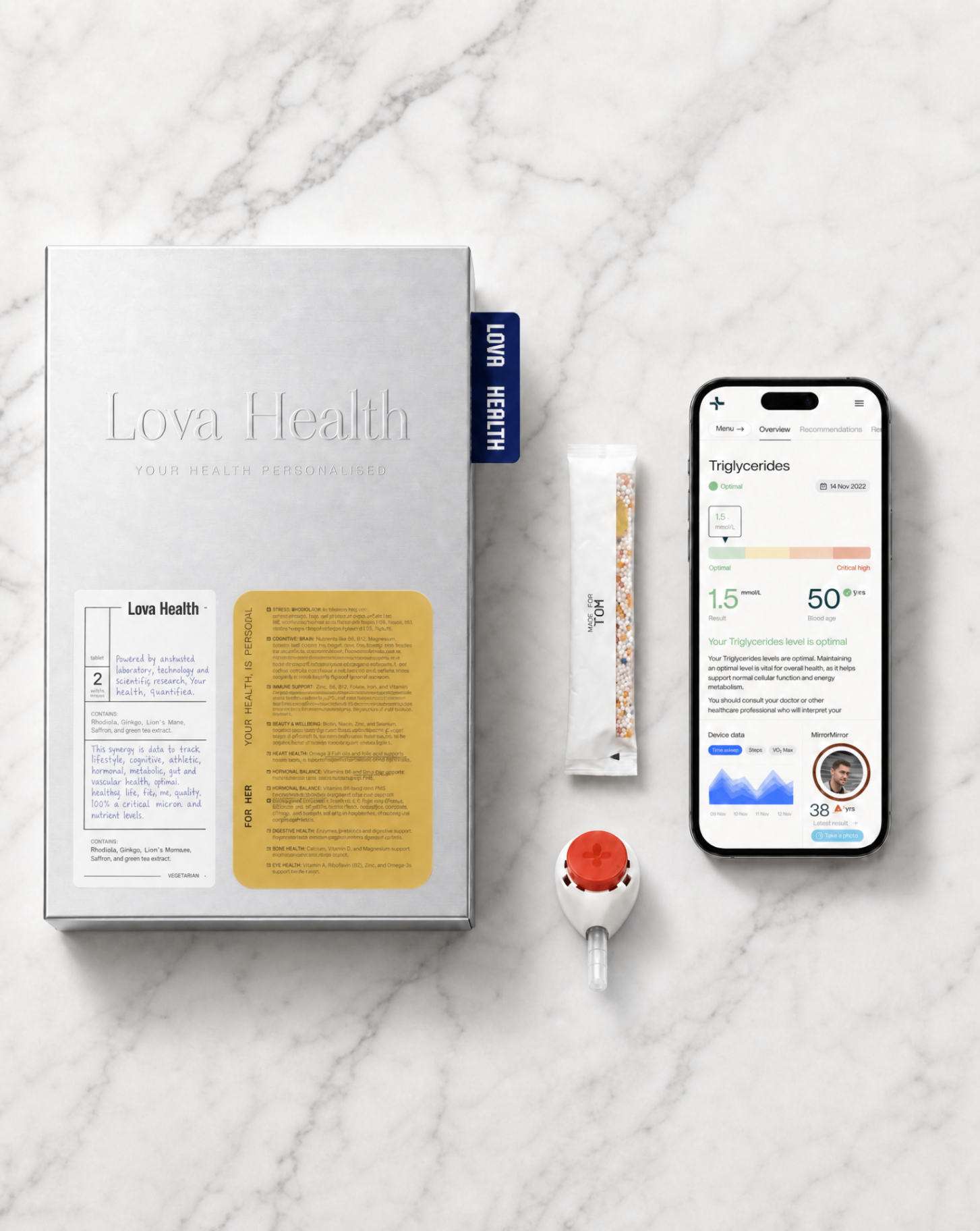 Lova Plus kit on white marble, silver box, sachet, blood test device, and phone showing biomarker dashboard
