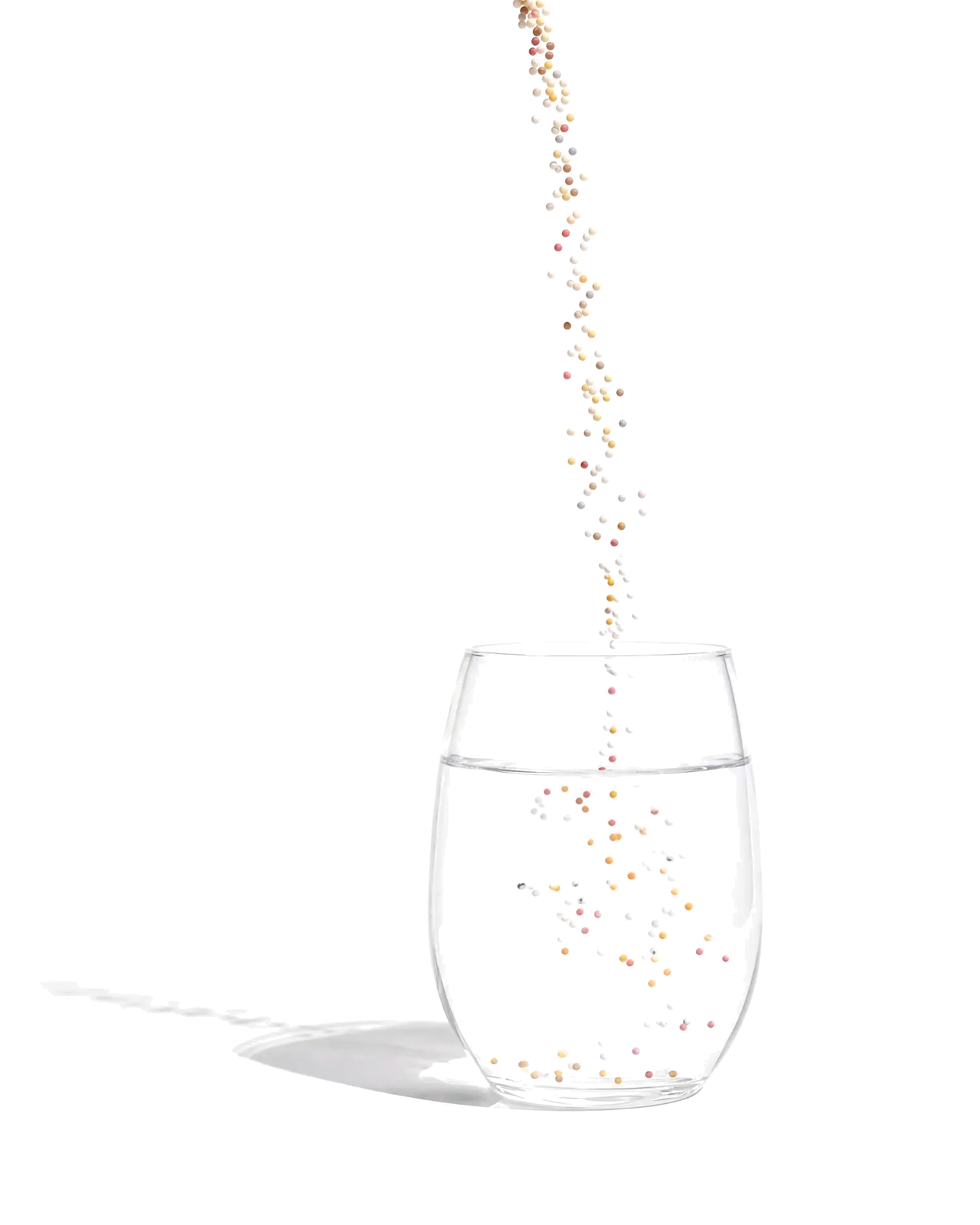 Clear glass of still water with Lova microgranules falling into it
